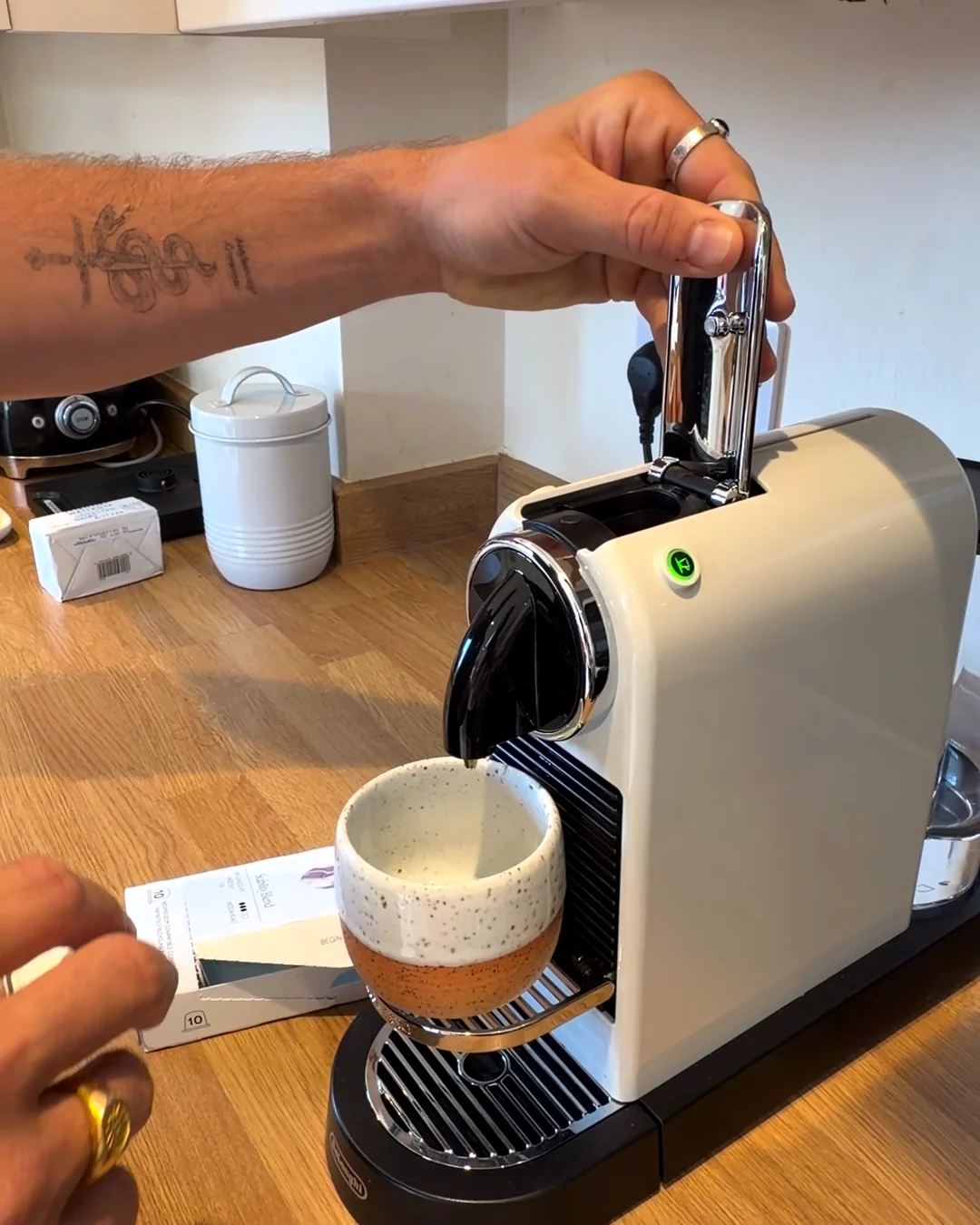 James lowering the lever on a Nespresso CitiZ with a cup under the spout