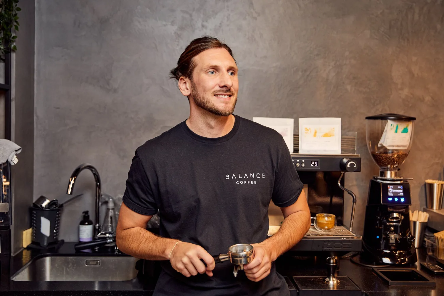 James Bellis behind an espresso machine, holding a portafilter